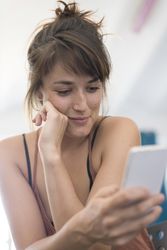 Shy woman reading something on phone