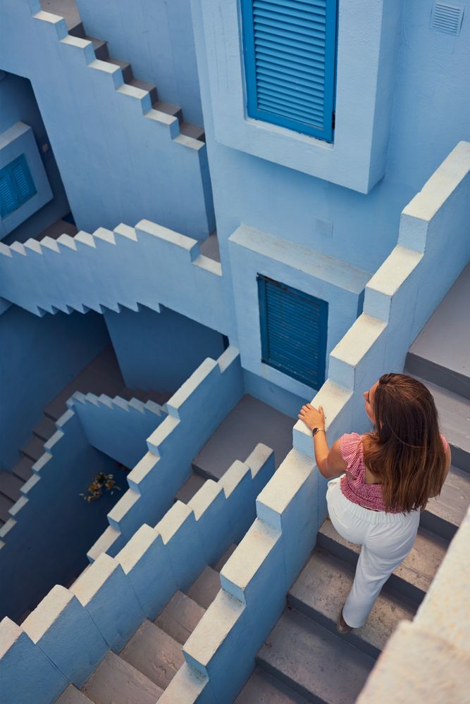 Woman walking downstairs on modern blue building