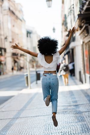 Black female jumping on urban background