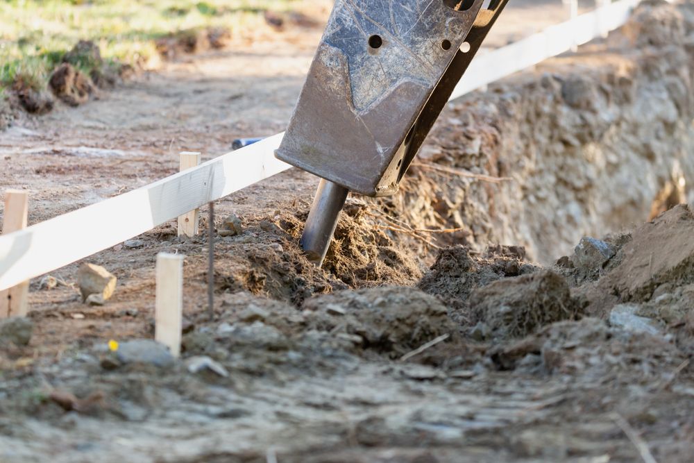 Small Bulldozer Using A Breaker Attachment To Dig Hole
