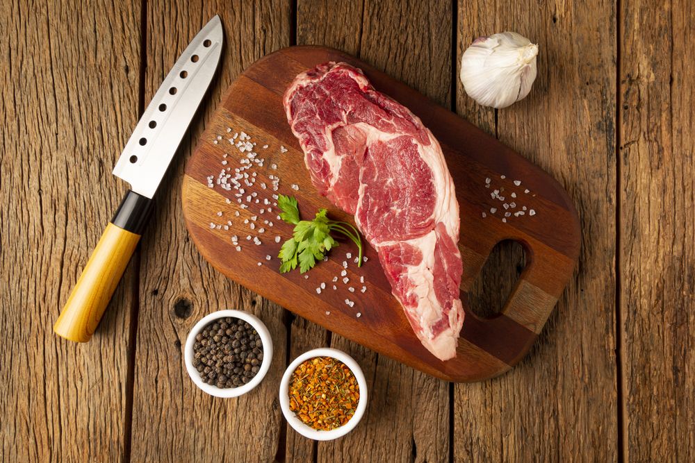 Raw ancho meat ready to roast on a wooden cutting board.