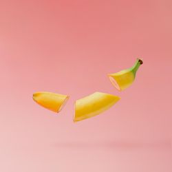 Banana slices on pastel pink background with copy space