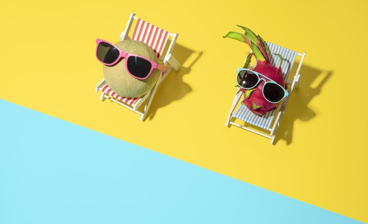 Summer holiday concept with exotic fruits on sunbeds on the beach
