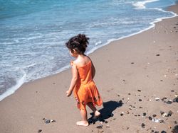 Little girl standing on beach and admiring view