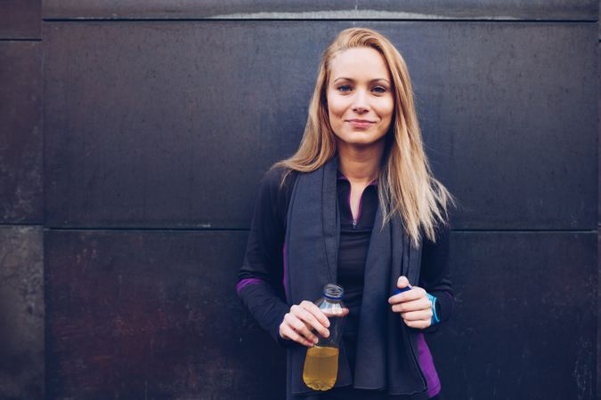 Woman drinking isotonic drink while resting