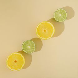 Fresh summer fruit with lemon and lime on sandy background
