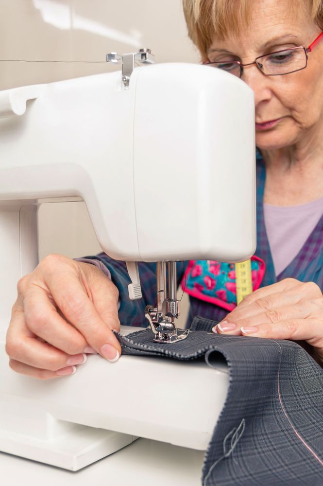 Mature seamstress woman working on sewing machine