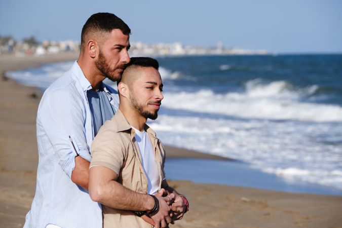 Gay couple hugging on seaside
