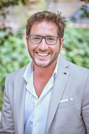 Smiling young man in modern clothes and eyeglasses