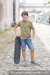 A teenage boy posing with skateboard and smiling 5r9Zy2