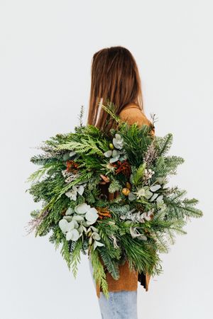Side view of mature woman holding Christmas garland