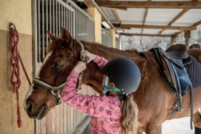 Woman and girl brushing horse