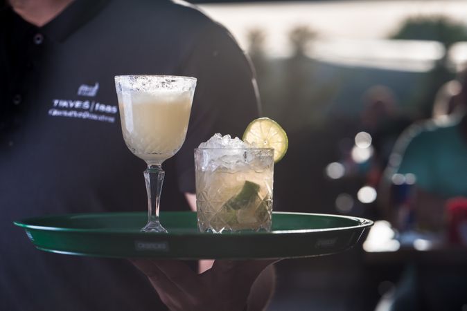 Waiter holding a tray of alcoholic cocktails