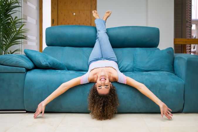 Woman lying backwards on sofa and smiling