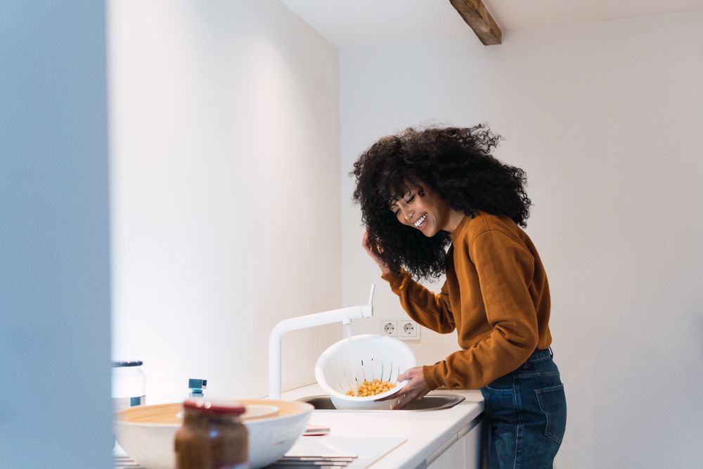 Woman washing chickpeas in sink