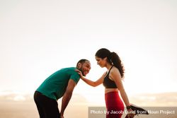 Cheerful fitness couple exercising standing outdoors 5zXaPb