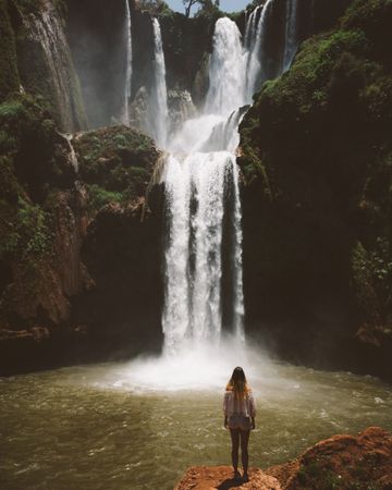 Woman in valley with amazing waterfall