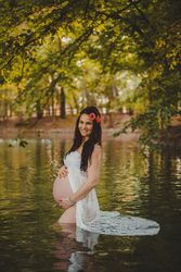 Pregnant woman standing in lake water