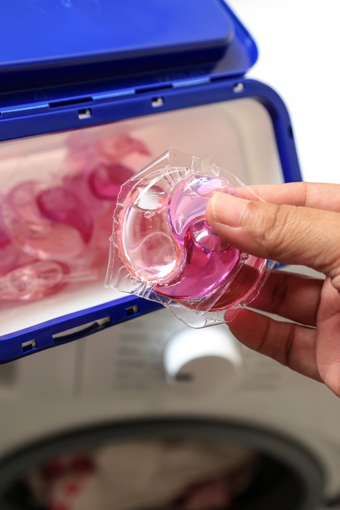 Hand Holding Gel Caps or Laundry Pods for Washing Machine.
