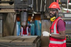 Male factory worker operating control big machine