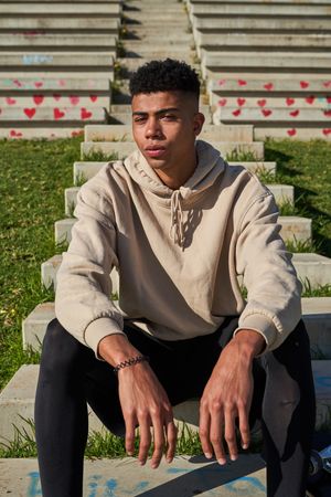 Confident Latino man sitting on stone stairway