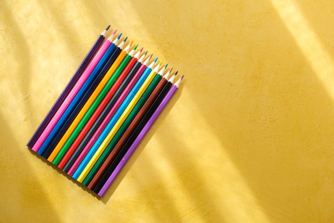 Coloured pencils for drawing on a yellow background