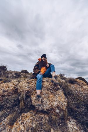 Cheerful woman resting on mountain top