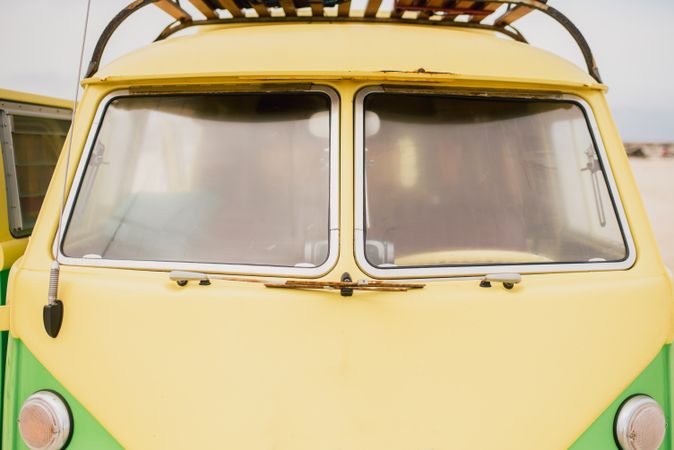 Bright retro minibus with round headlights on beach
