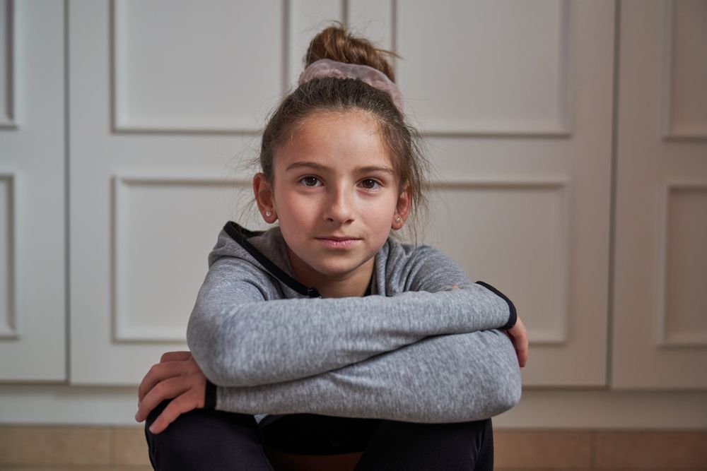 Portrait of gymnastic girl sitting at home