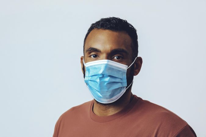 Male wearing medical face mask looking at camera in studio shoot