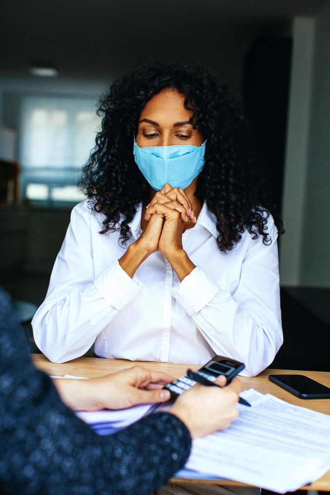 Woman going through numbers with a colleague wearing a facemask