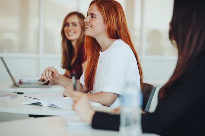 Student with beautiful red hair sitting as desk in classroom