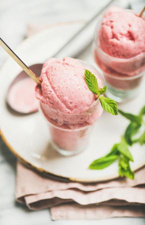 Homemade strawberry yogurt ice cream with fresh mint, vertical composition