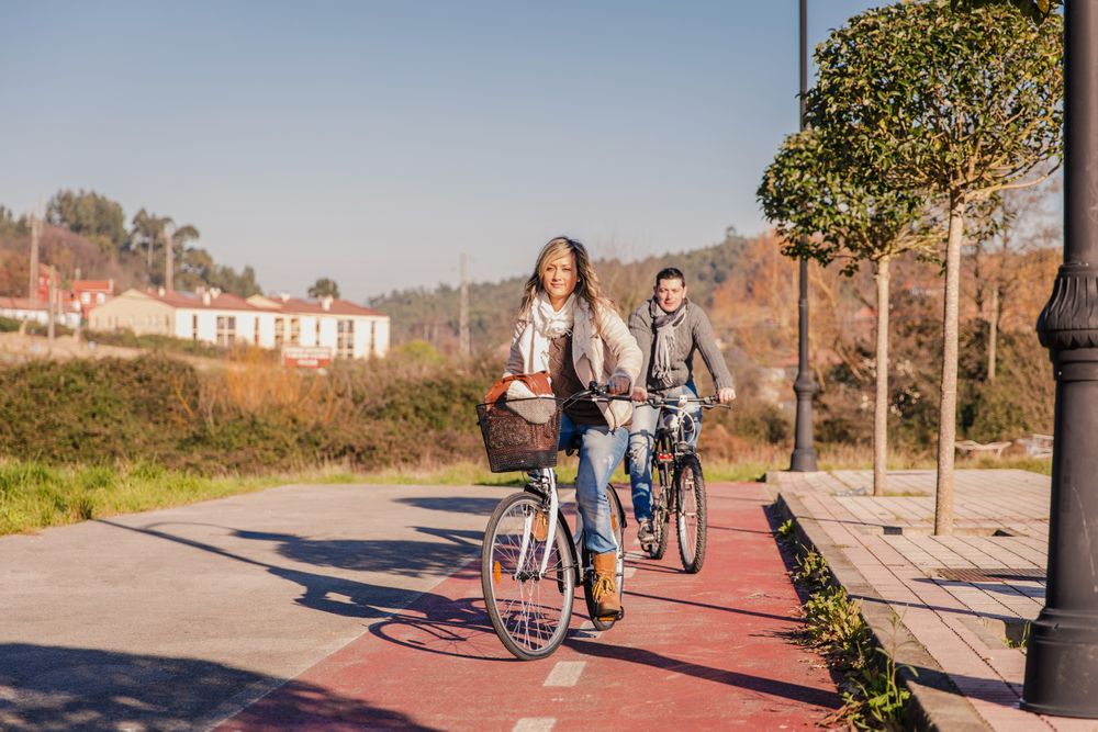 Man and woman riding bikes in bike lane on sunny winter day