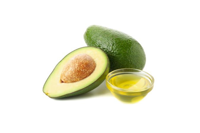 Ripe fresh avocado and oil isolated on blank background