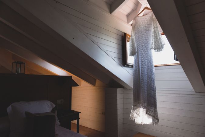 Dress hanging near window in room