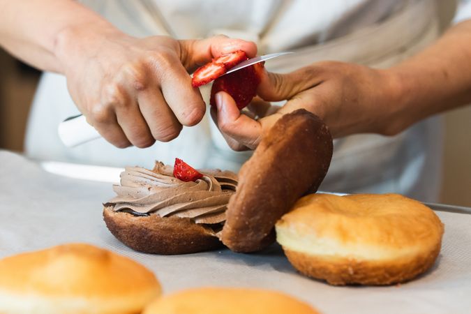Crop baker preparing delicious vegan sponge cakes at table