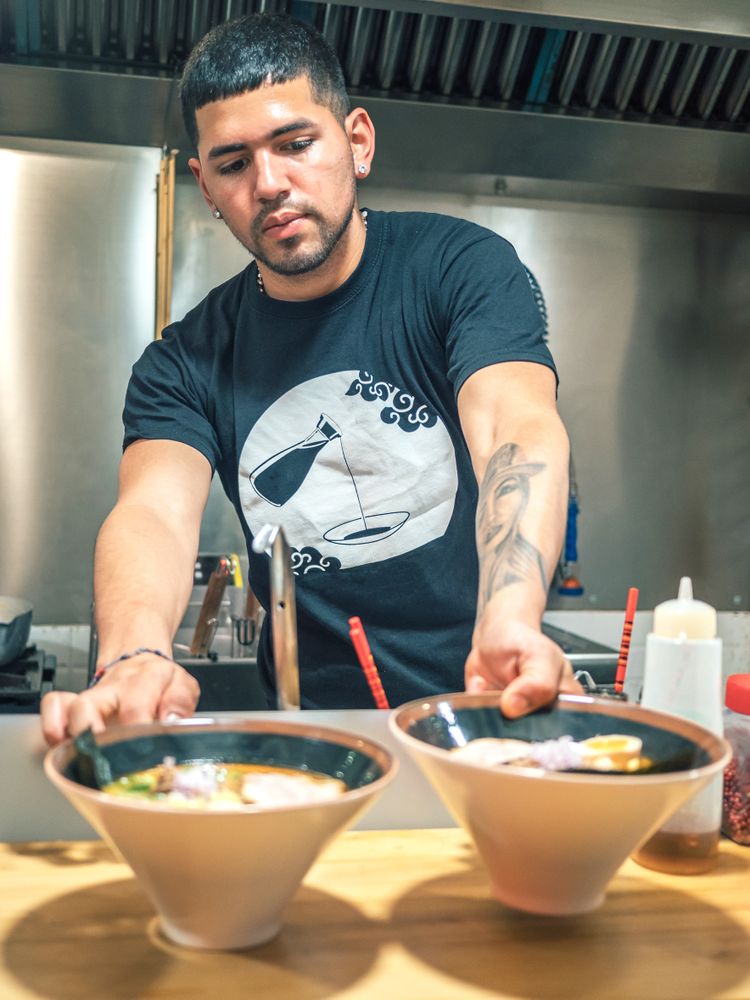 Male serving bowls with soup in restaurant