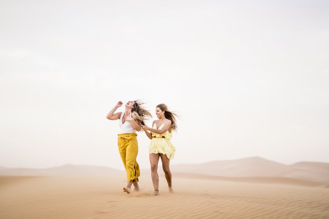 Happy women walking in the desert in desert