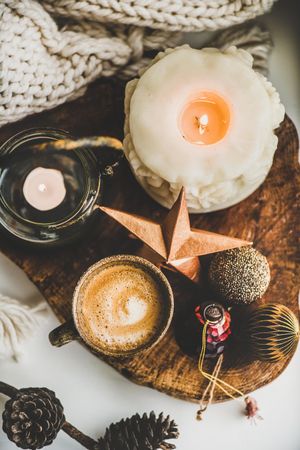 Coffee, candles, festive decorations on wooden board