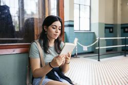 Woman reading a book at an old train station