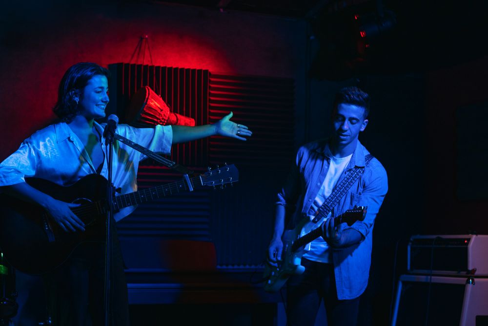 Musicians In Stage With Colorful Lights Performing In A Live Concert