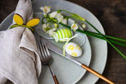 Table setting for Easter dinner with egg decor and flowers