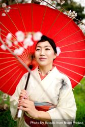 Japanese woman in light kimono holding a red umbrella 0Vyekb