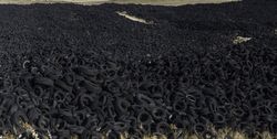 Heap of old tires between field
