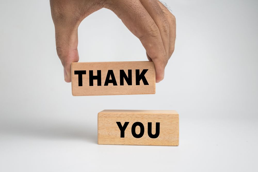 male hand putting thank words symbol on wooden blocks