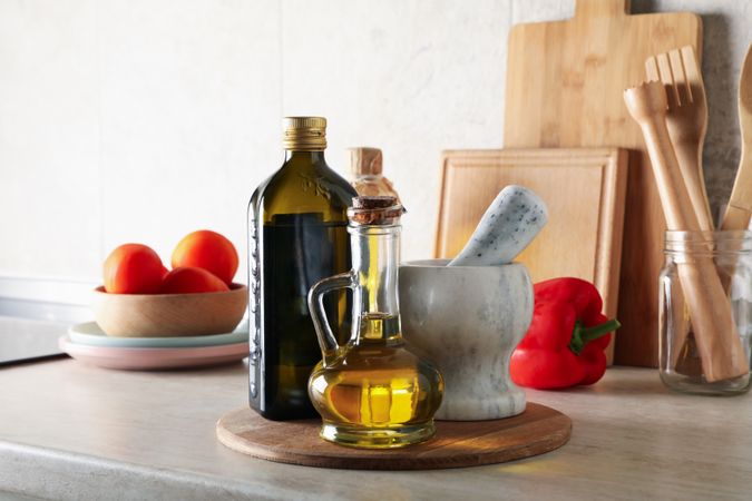 Kitchen table with different supplies and bottles with oil