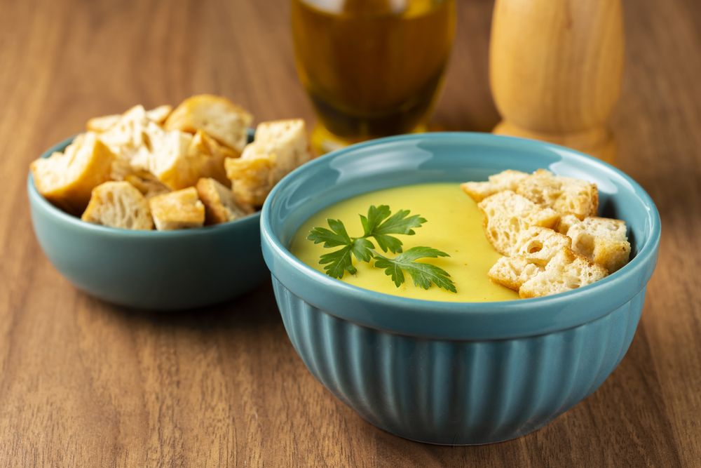 Bowl with onion soup and croutons on the table.