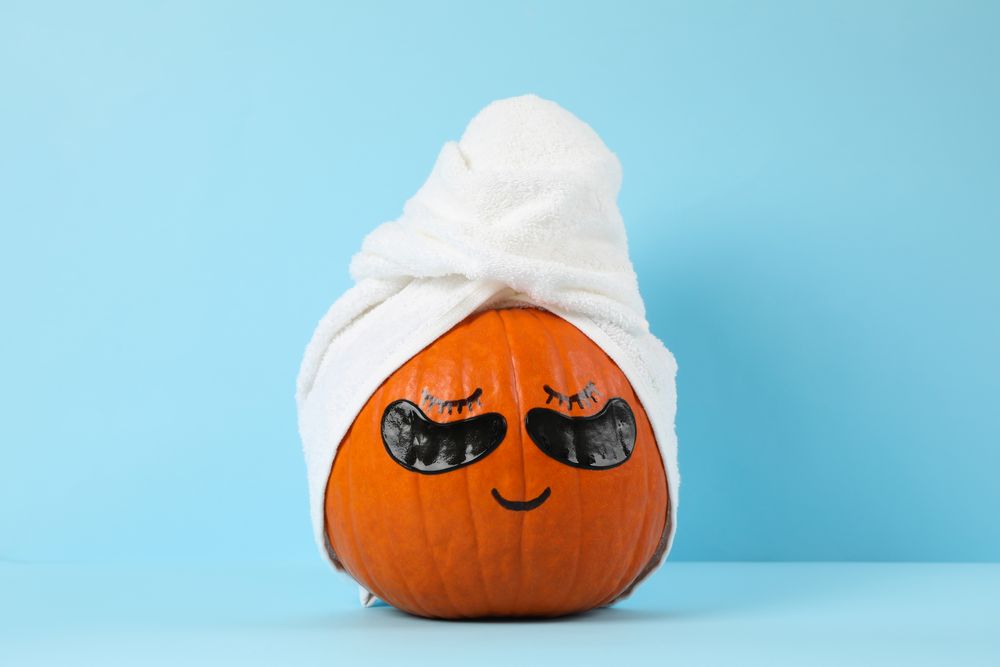 Pumpkin with towel and under eye patches against blue background