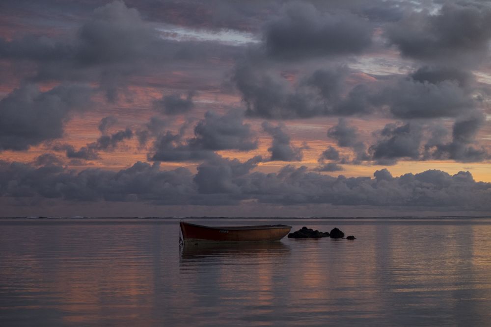 A single boat on a vast ocean at dawn